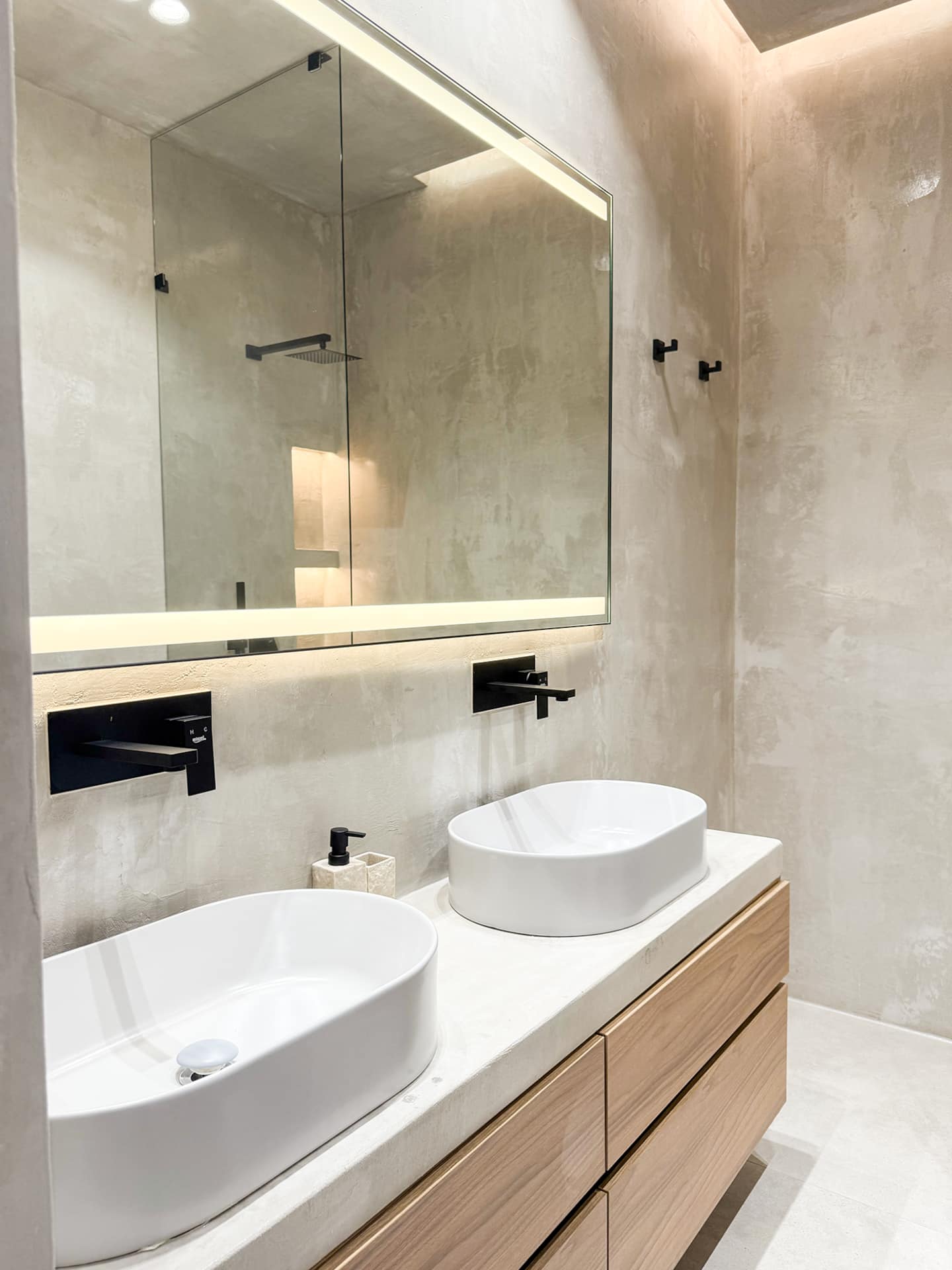 Full bathroom at Villa 4 — double sink and warm oak joinery.