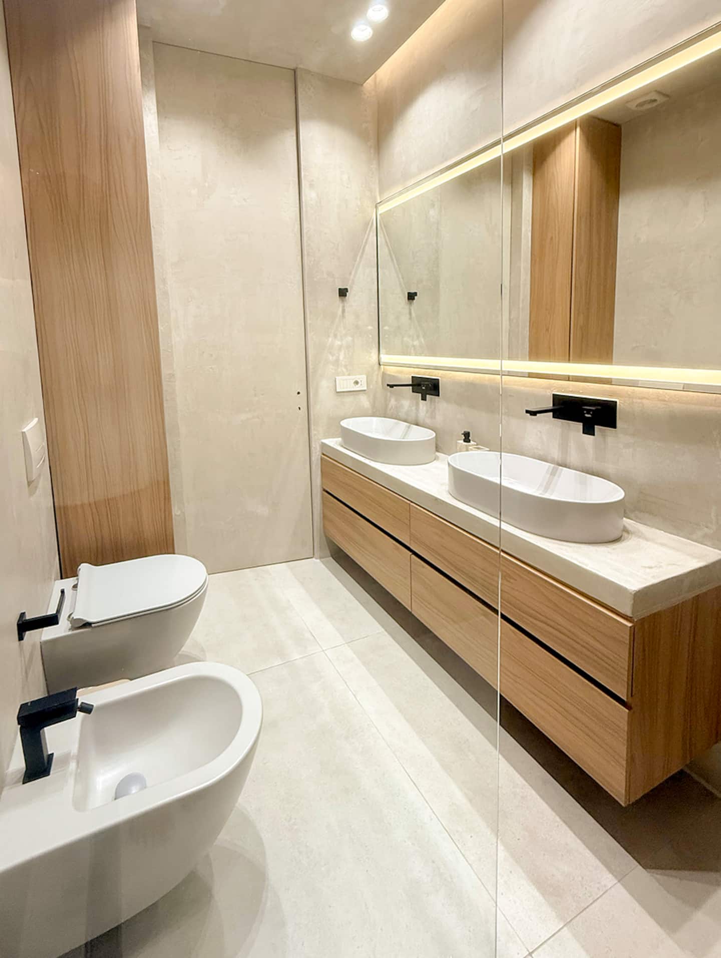 Full bathroom at Villa 4 — double sink and warm oak joinery.
