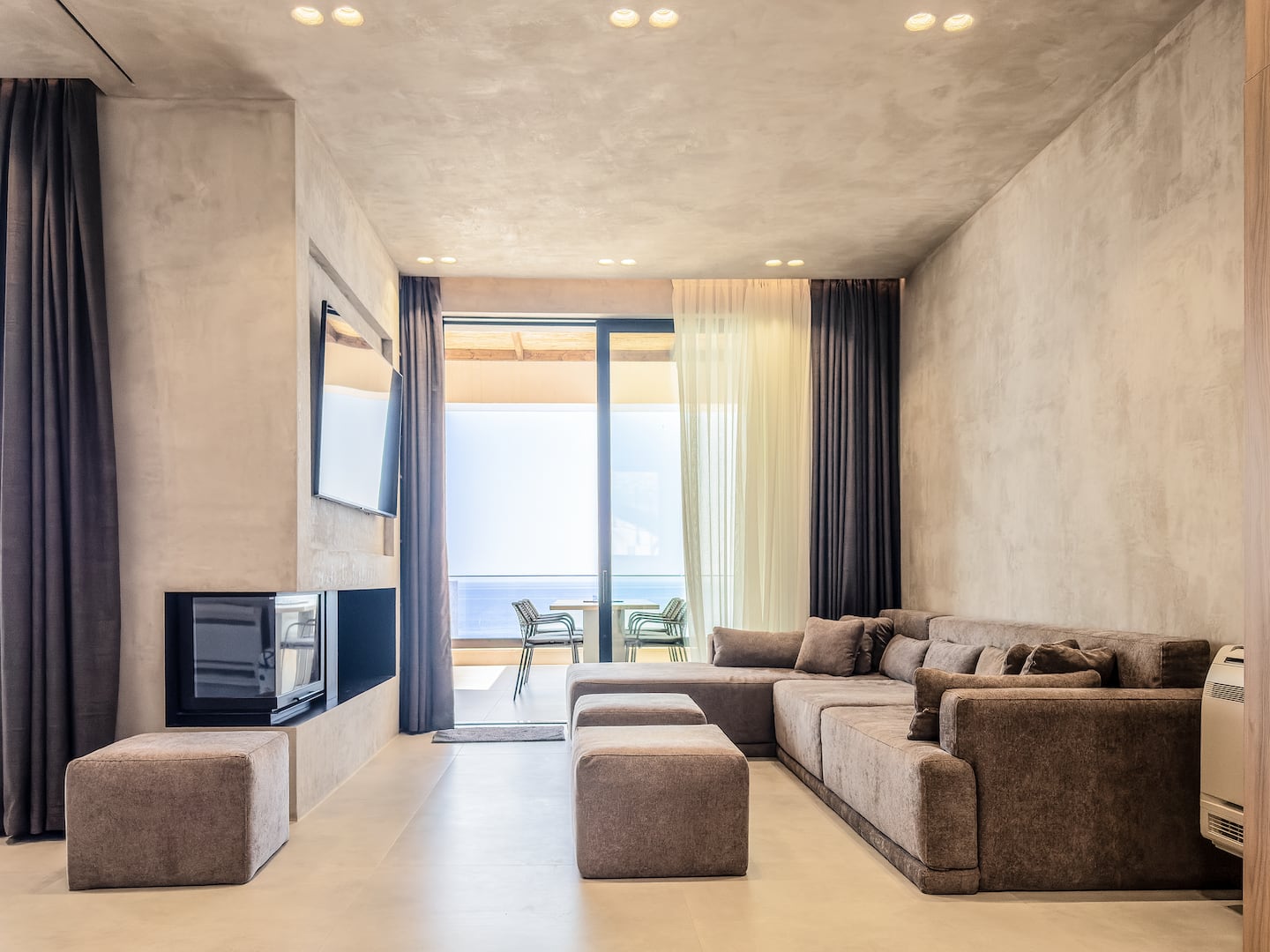 Living room at Villa 4 with fireplace and Ionian sea views.